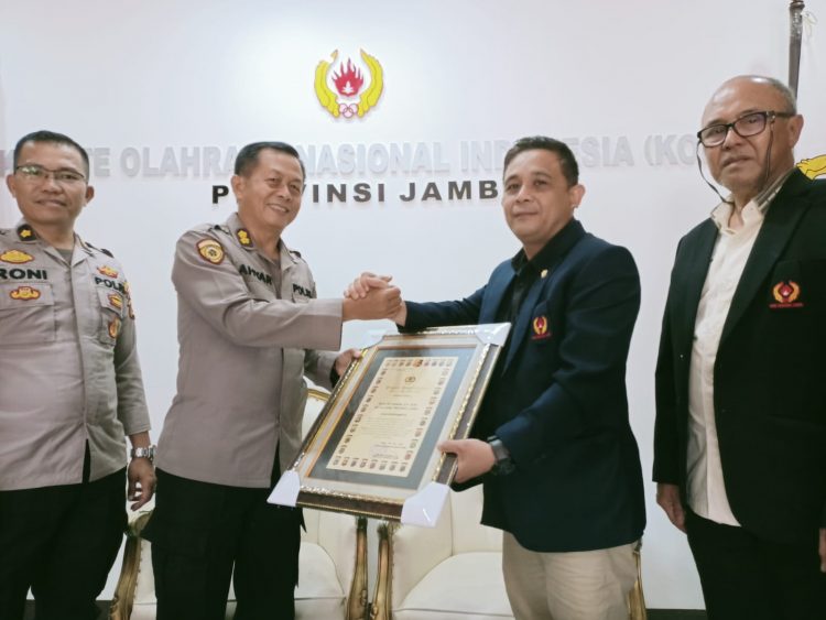Keterangan foto : Kabag Watpers Biro SDM Polda Jambi, AKBP Ahyar, S.E, menyerahkan piagam penghargaan ke ketum KONI Provinsi Jambi.(foto by Chun)