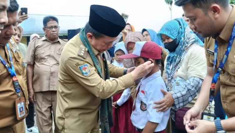 Tampak Gubernur Jambi Memasang Alat Pendegar Kepada Siswa SD (Dok Foto:Rky)